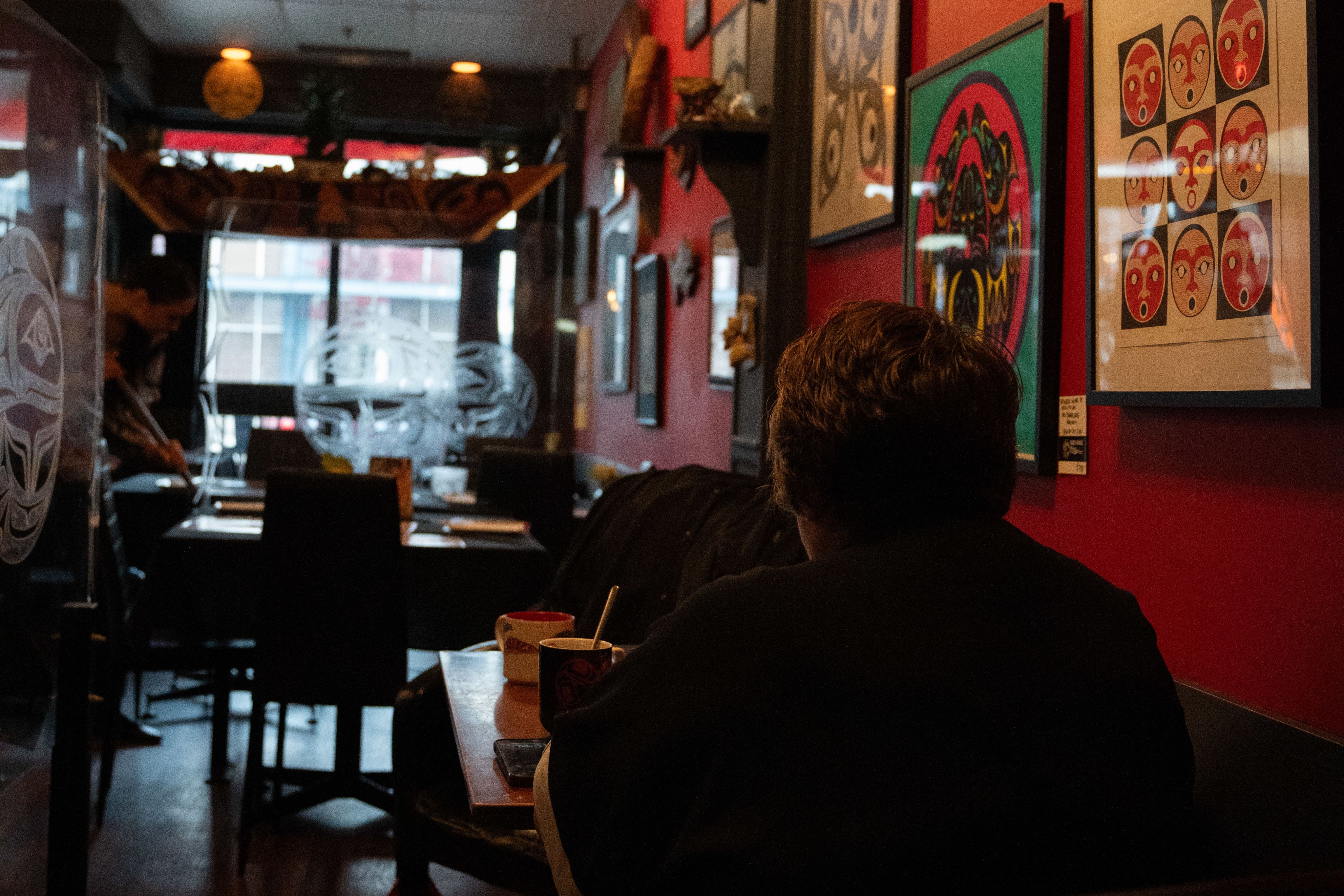 Co-founder and owner Inez Cook sits at a table before service begins at Salmon n' Bannock. Coordinating and firefighting are big parts of her job as a business owner.