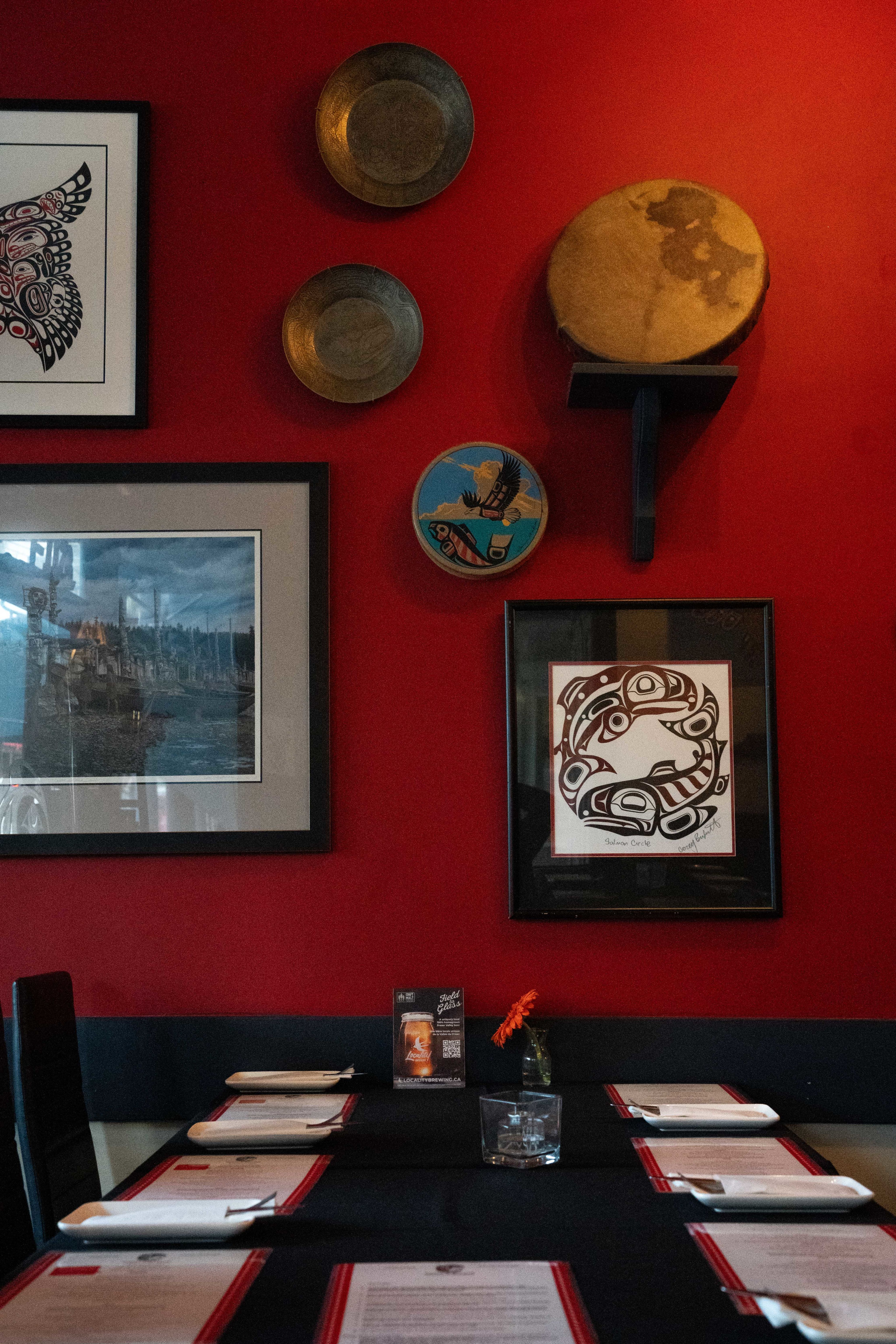 A table at Salmon n' Bannock with art on the wall